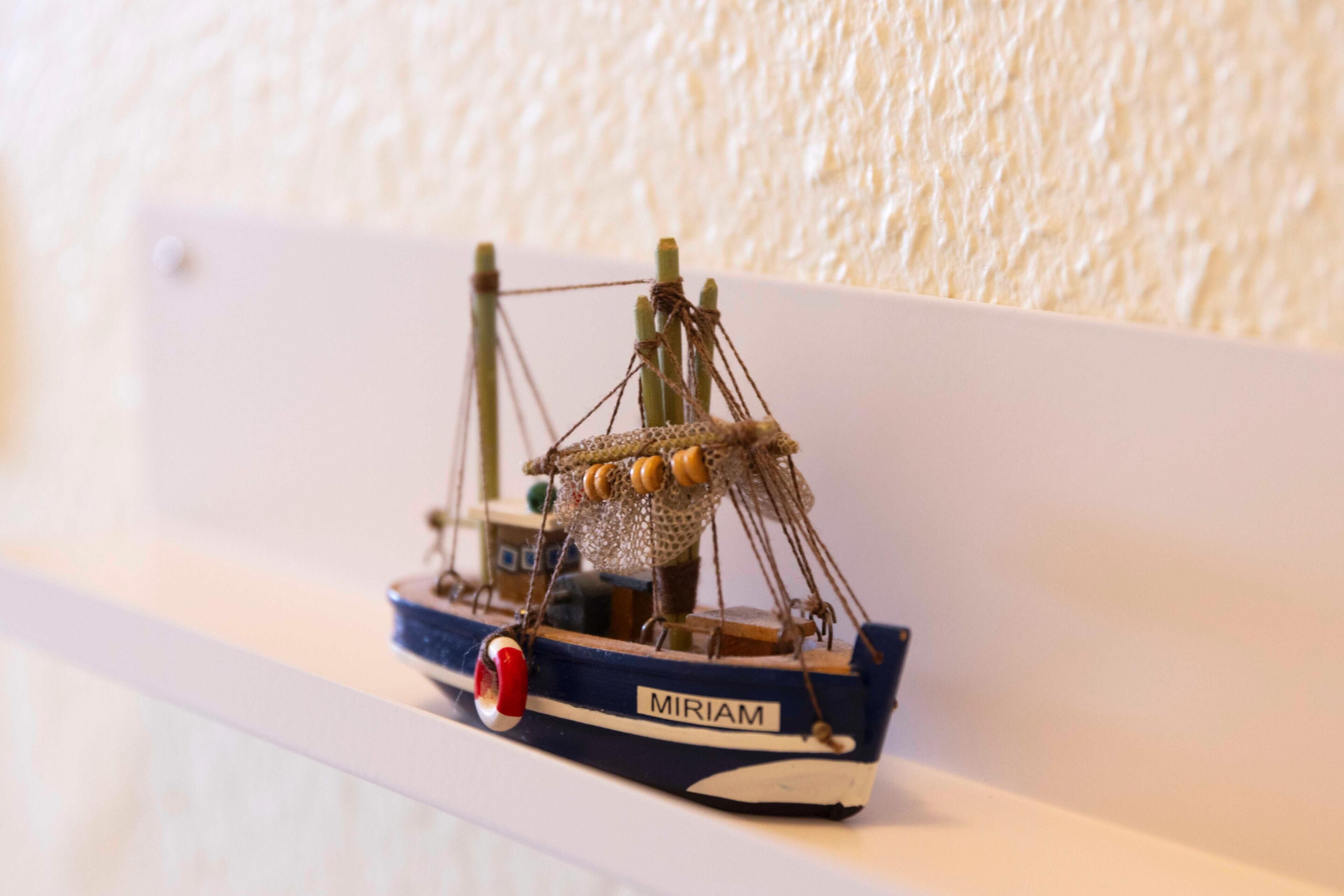 A model ship named "MIRIAM" on a shelf.