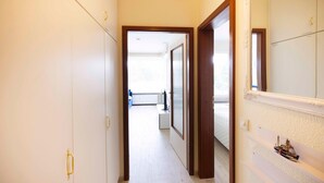 Un couloir étroit avec une porte donnant sur un balcon.