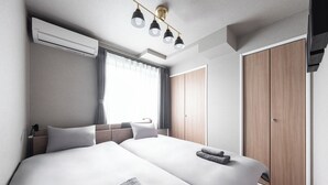 A modern hotel room with two beds, a large window with curtains, a wardrobe, and a ceiling light fixture. - THE OBSIDIAN  (Sapporo)