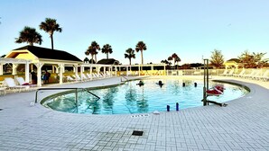 A pool area with lounge chairs and palm trees. - Dessert First - Cozy 2/2 in The Village of DeLuna Accepts a Small Dog with pre-approval (The Villages)
