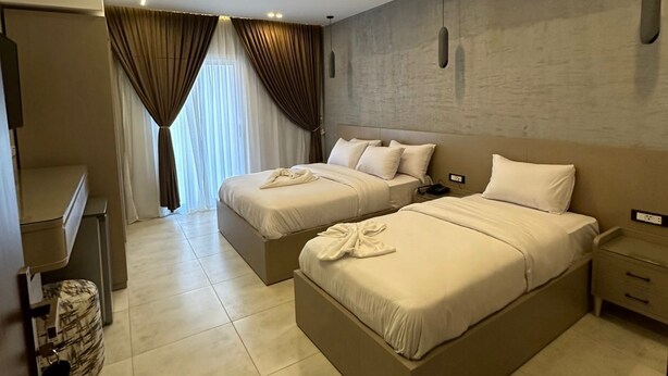 Een hotelkamer met twee bedden, een bureau en een kledingkast.