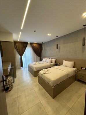 A hotel room with two beds, a desk, and a wardrobe. - CASTELLO HOTEL CAIRO (Cairo)