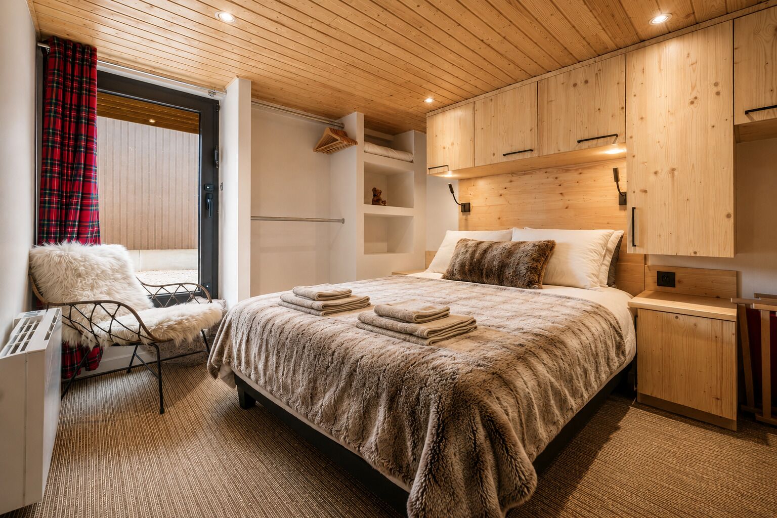 Une chambre moderne avec un grand lit, une tête de lit en bois et une vue sur l’extérieur.