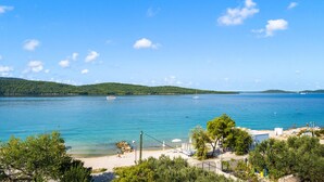 A coastal view with a beach, clear blue water, and distant hills. - Stunning apartment in Sibenik with WiFi (Sibenik)
