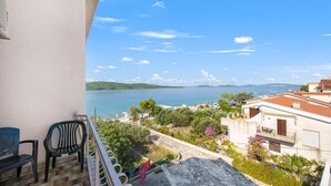 A balcony with two chairs, a view of a lake, and surrounding greenery. - Stunning apartment in Sibenik with WiFi (Sibenik)