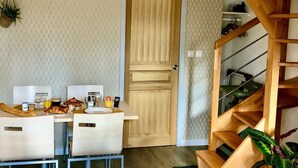 Une table de petit-déjeuner, des chaises et un escalier en bois.
