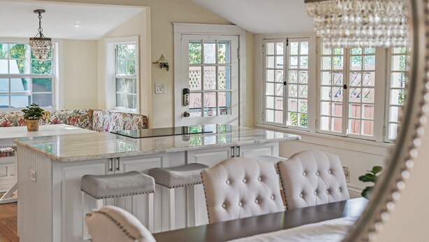 A modern kitchen with a central island, bar stools, and a dining table. - Historic St Augustine | Courtyard Fireplace | Dog Friendly (St. Augustine Beach)