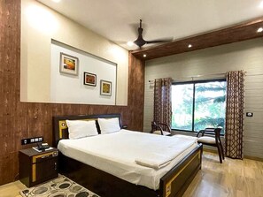 Une chambre d’hôtel moderne avec un grand lit, un bureau et une fenêtre avec des rideaux.
