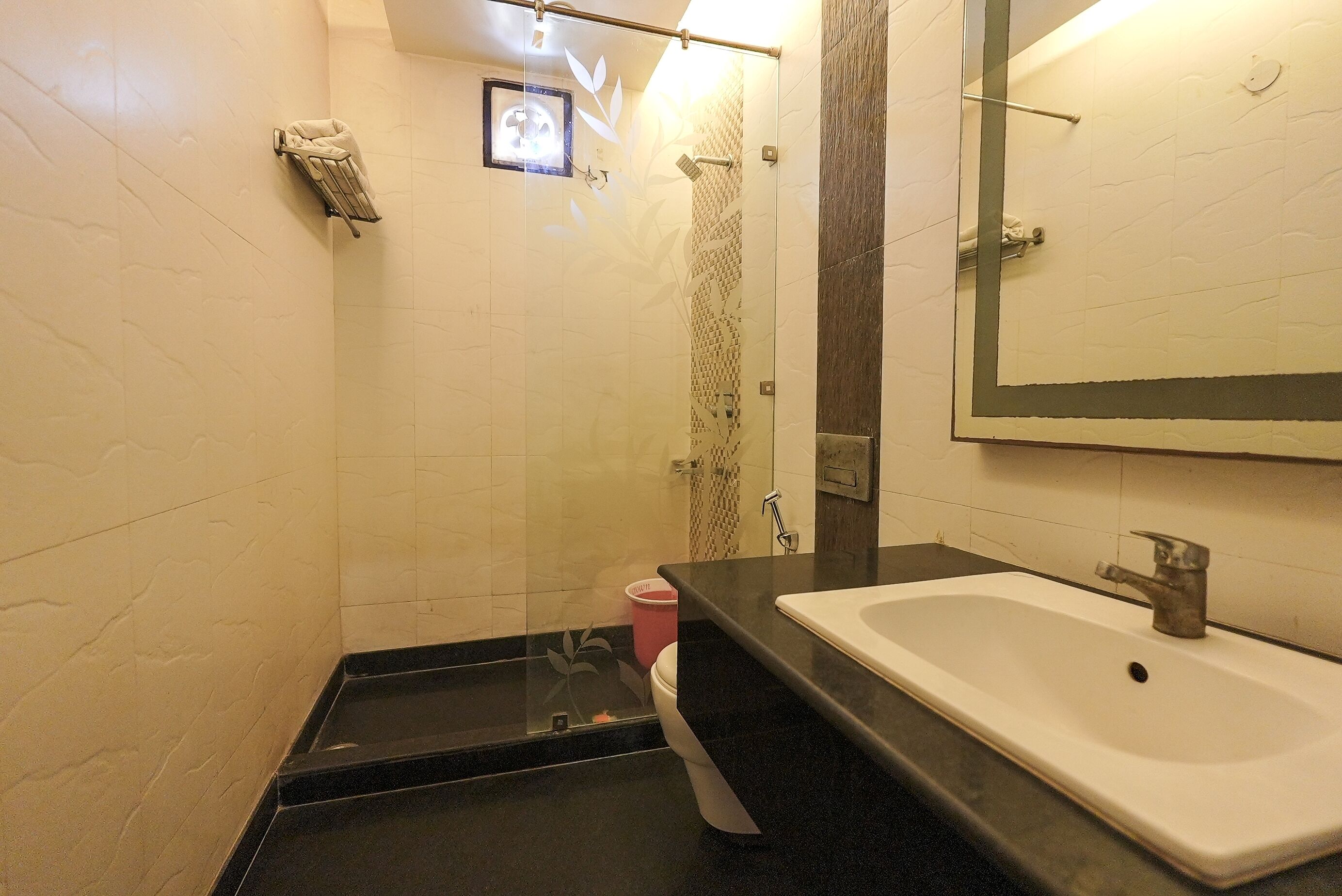 A bathroom with a white sink, a mirror, and a shower area.
