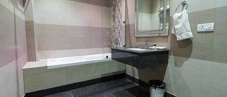 A bathroom with a bathtub, a sink, a mirror, and a towel rack.