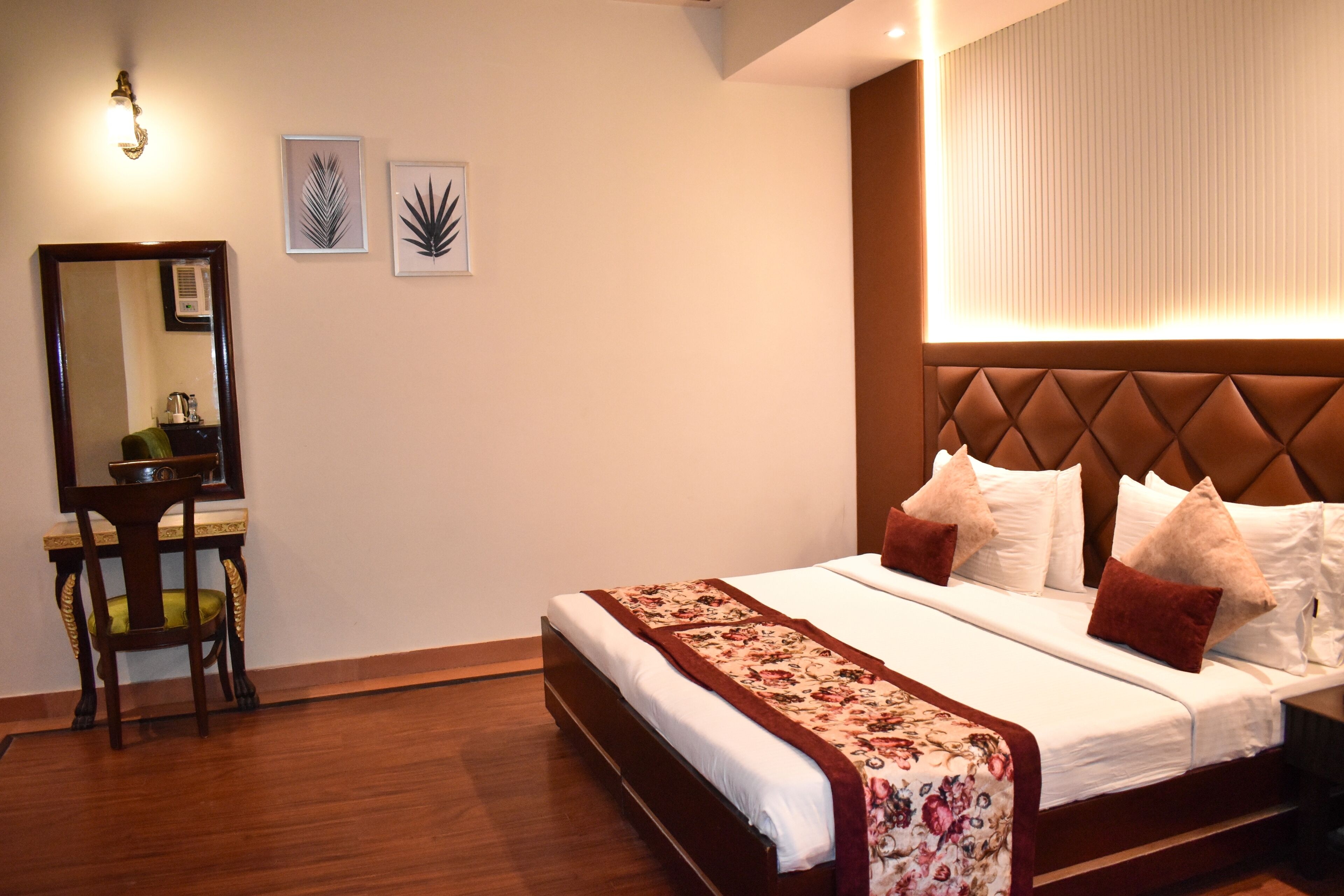 A neatly arranged hotel room with a large bed, a bedside table, and a chair.