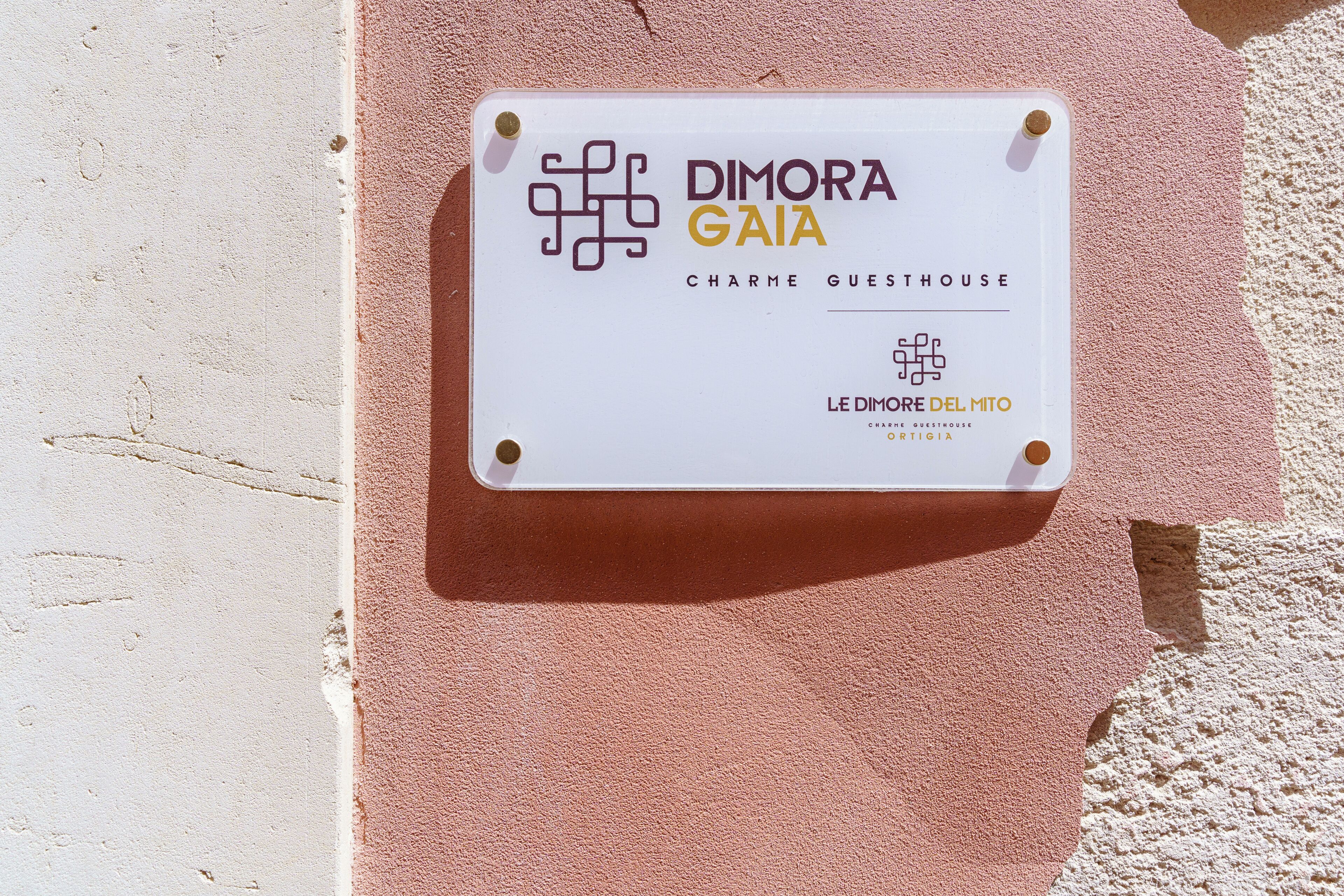 A sign for 'DIMORA GAIA Charme Guesthouse' with a logo and name.