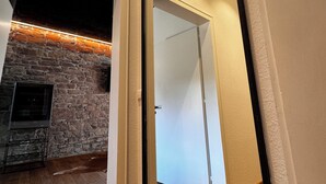 A modern interior with a stone wall, wooden flooring, and a white door.