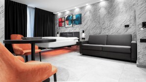 Un salon moderne avec un canapé, une table à manger et des chaises orange.