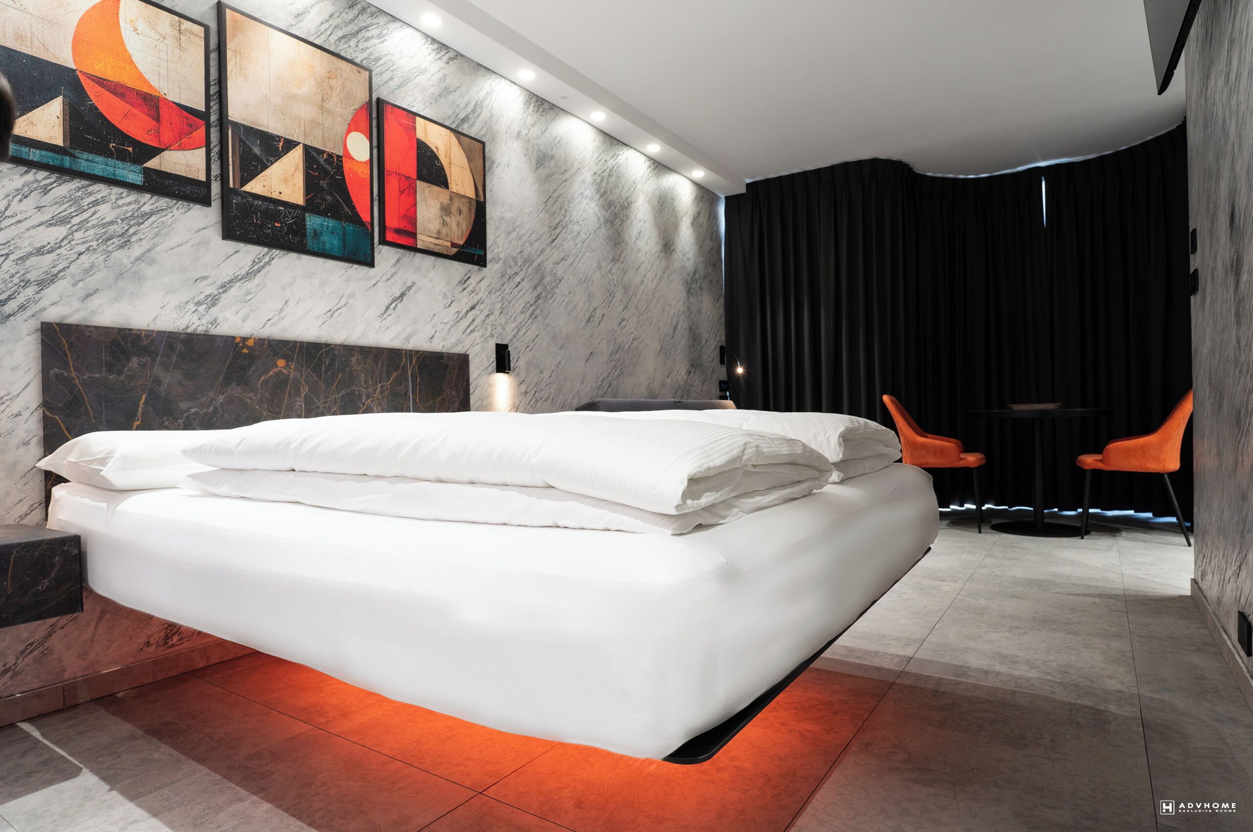 Una camera da letto moderna con un letto grande, una testiera in marmo e opere d'arte alle pareti.