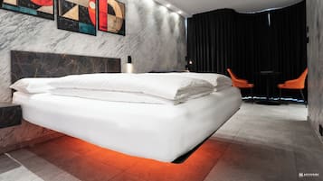 Un dormitorio moderno con una cama grande, cabecera de mármol y obras de arte en la pared.