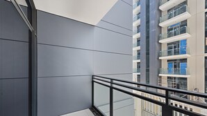 Een modern gebouw met een glazen balkon en uitzicht op andere gebouwen.