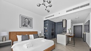 Een moderne hotelkamer met een groot bed, een kitchenette en een badkamer.
