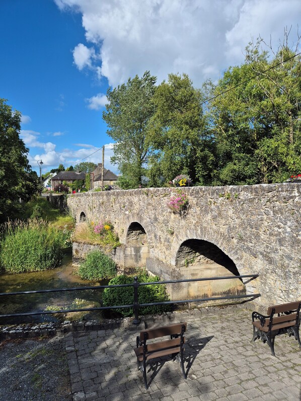 A stone bridge with arches, a paved walkway, and benches. - Tranquil Carney Commons Cottage - Sleeps 10 (Congor)