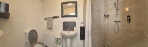 A bathroom with a toilet, sink, mirror, towel rack, shower, and a radiator. - Tranquil Carney Commons Cottage - Sleeps 10 (Congor)