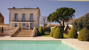 A two-story building with a pool in the foreground. - Maison de Maître 4* Piscine, Vignobles & Plages 6 pers. - Coeur Cristal (Magalas)