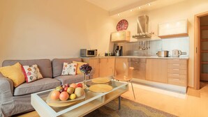 Apartamento moderno com sala de estar, cozinha compacta e área de refeições.