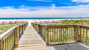 A wooden boardwalk leading to a beach with a clear sky. - The Palms 501 by Liquid Life (Orange Beach)