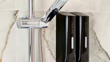 A bathroom with a modern shower setup, including a chrome faucet and a handheld showerhead.