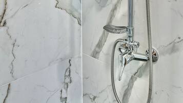 A modern shower with a handheld showerhead, a fixed showerhead, and a handheld shower hose.