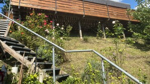 Ein modernes Gebäude mit einer Holzterrasse und einer Treppe, die dorthin führt.