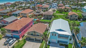 A residential area with houses, a swimming pool, and a view of the ocean. - 121 E Aries - Angel's Paradise (South Padre Island)