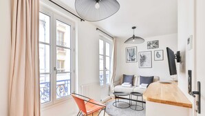 Un appartement moderne comprenant un coin cuisine, une table à manger et un ensemble de canapés.