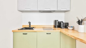Une cuisine avec un plan de travail en bois, un évier, une cuisinière et des placards.