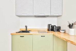 Una cocina con encimera de madera, un fregadero, estufa y armarios.