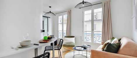 Un espace de vie moderne comprenant un coin repas, un canapé et une table basse ronde.