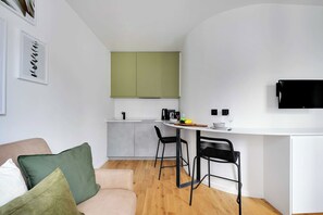 A compact living space with a kitchenette, a sofa, and a dining area. - Cosy Studio - 4P/1B  - Gare de Lyon / Bastille (Paris)