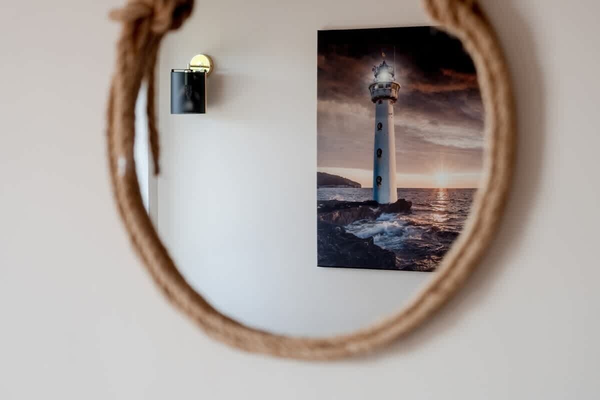 A framed photograph of a lighthouse at sunset.