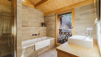 Une salle de bain moderne avec un plafond en bois, une baignoire, une douche et un lavabo.