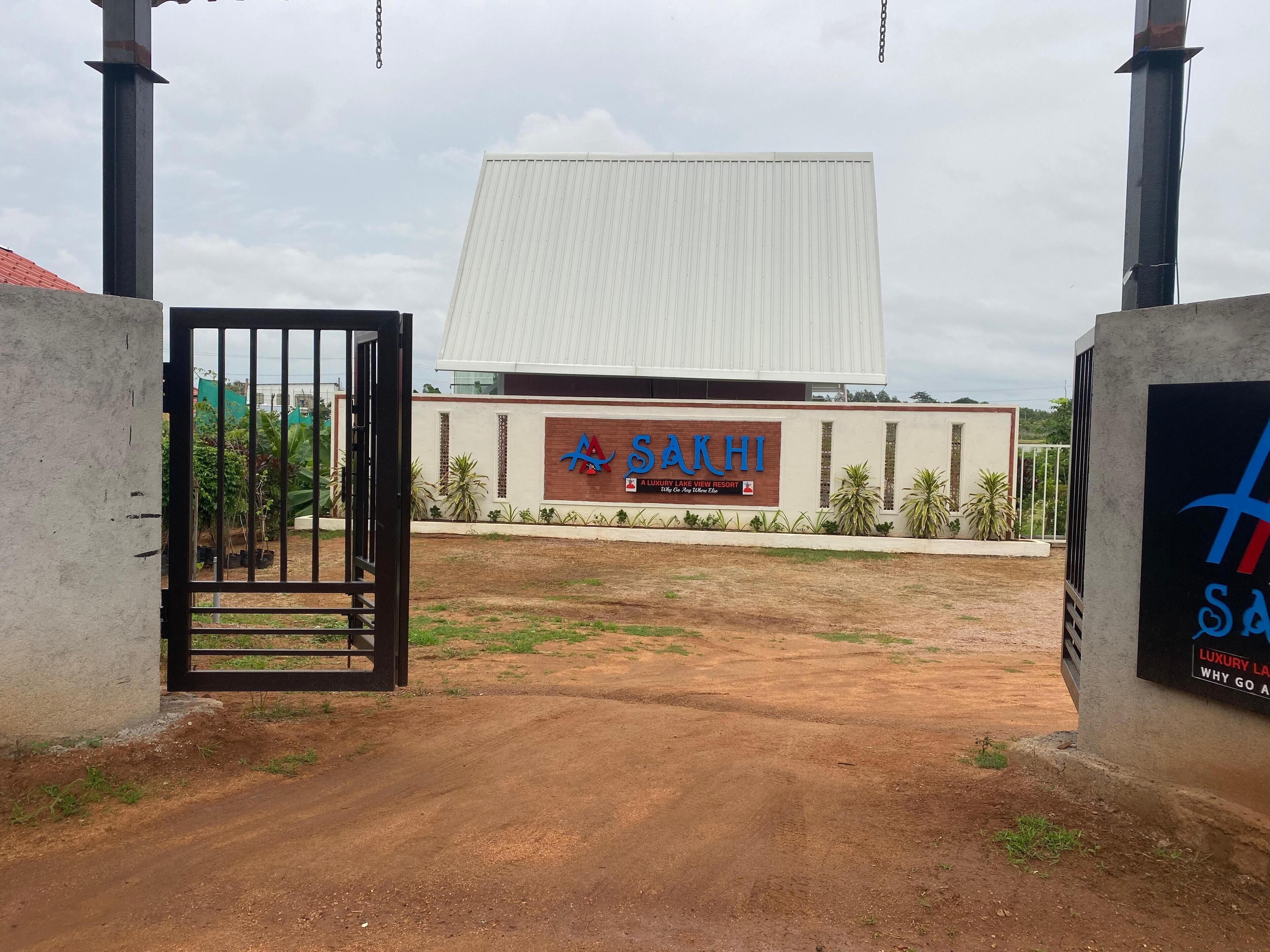 A gated entrance to a building with a sign reading "SAKHI A LUXURY LAKE VIEW RESORT".