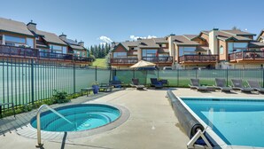 Ein Poolbereich mit Whirlpool, Liegestühlen und einer Umzäunung.