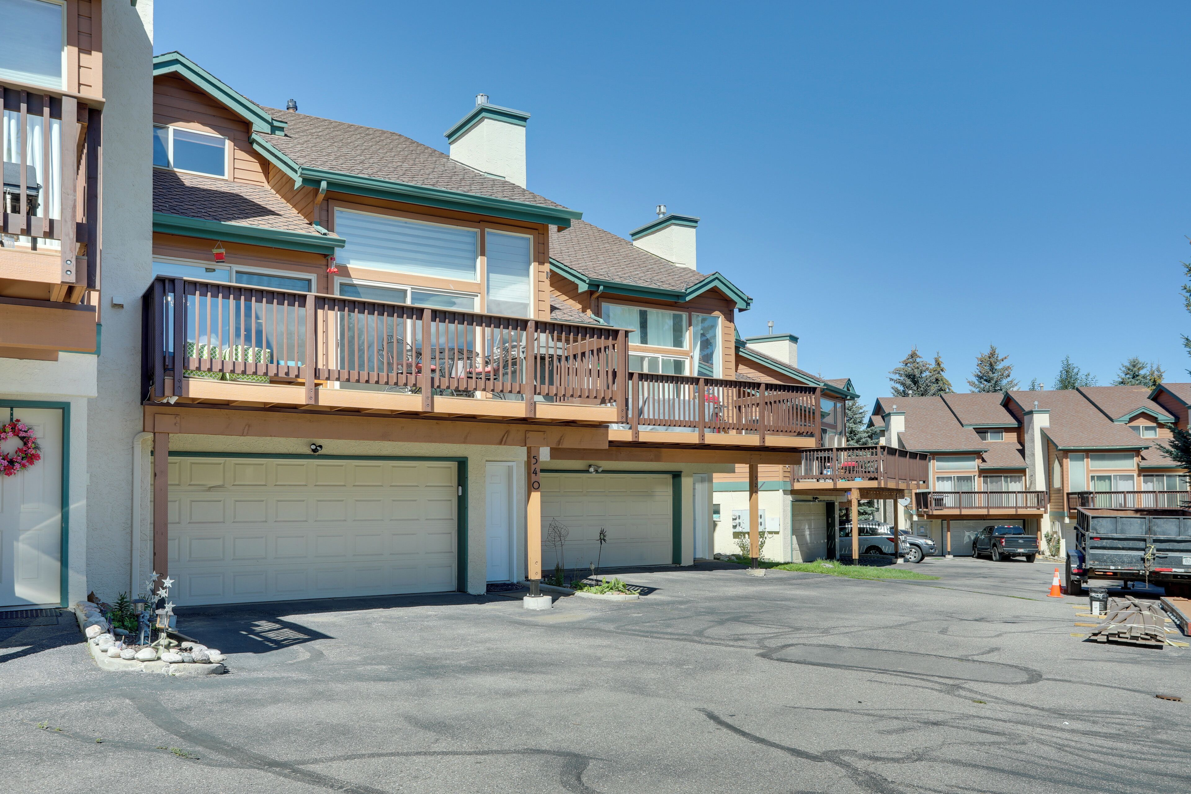 A multi-story residential building with a garage, a balcony, and a small garden area.