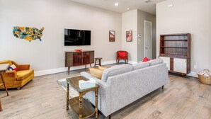 A living room with a sofa, a coffee table, a television, and a map of the USA on the wall. - 2 Mi to Dtown: Convenient Houston Home! (Houston)