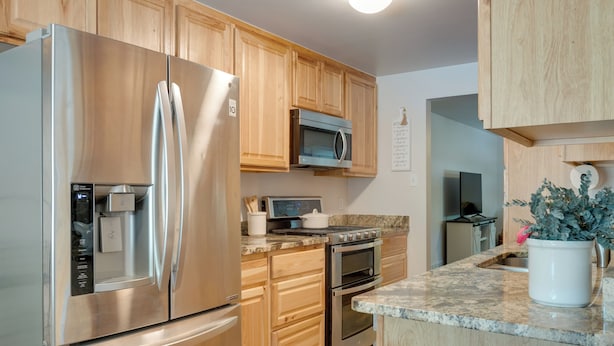 A modern kitchen with stainless steel appliances, wooden cabinets, granite countertops, and a potted plant. - 6 Mi to Denver: Wfh-friendly Duplex in Wheat Ridge (Wheat Ridge)