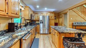 A modern kitchen with wooden cabinets, stainless steel appliances, and granite countertops. - Deck & Private Hot Tub: Cabin in Ellijay! (Ellijay)