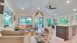 A spacious living area with a sofa, coffee table, and a kitchen island. - Deck & Fire Pit: Near ATV Trails in Gaylord (Gaylord)