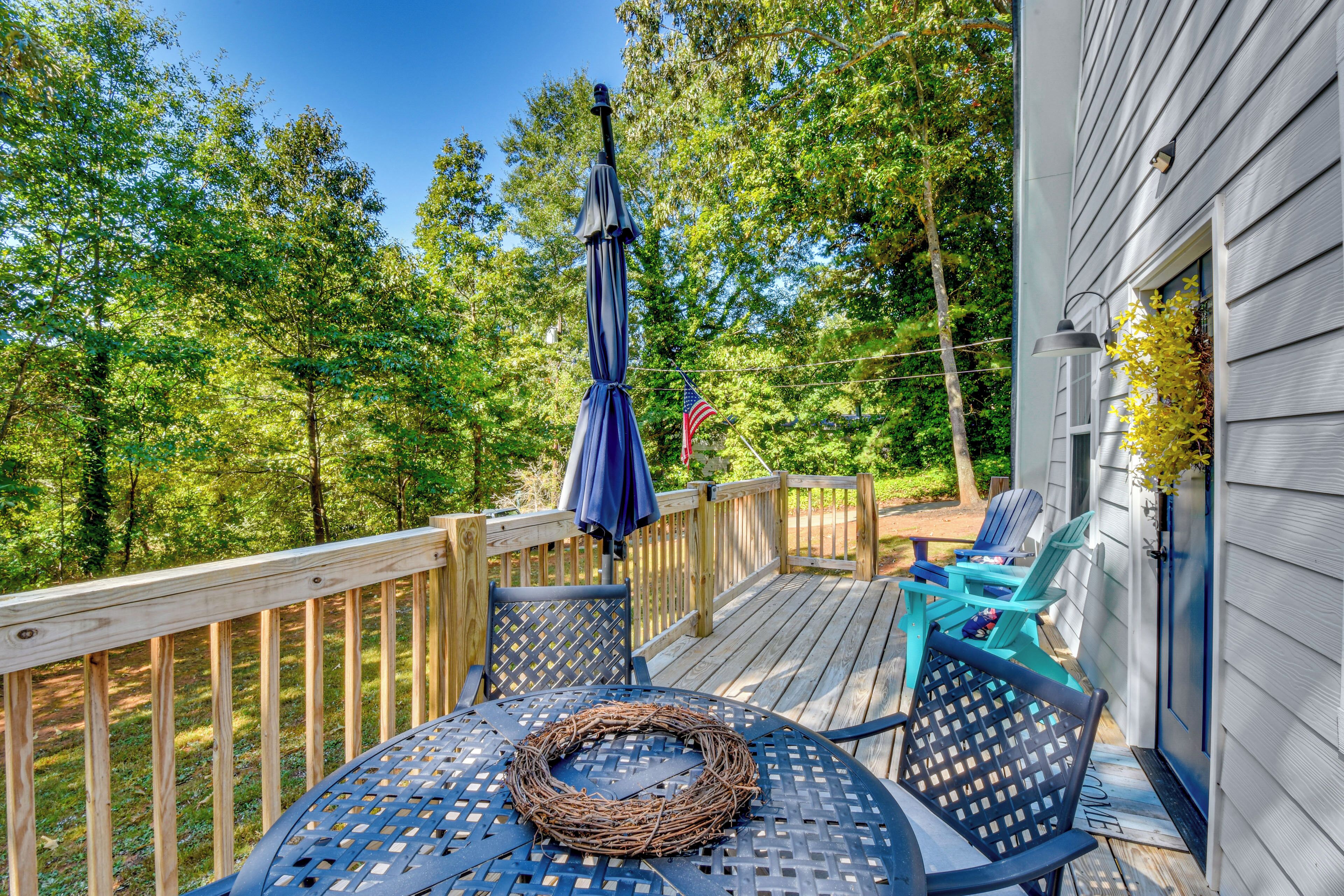 A deck with a table and chairs, surrounded by a wooden railing, and an American flag.