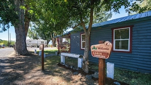 A cabin with a 'Welcome' sign, a bench, and a covered area. - 'crater Lake' Williamson River Resort Cabin 1 (Chiloquin)
