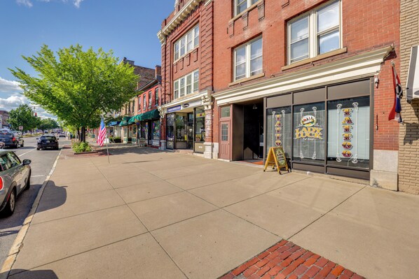 Une vue de rue avec un bâtiment en briques, des devantures de magasins et un trottoir.