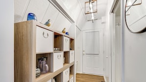 A hallway with wooden shelves, a white door, and a light fixture. - A-frame Home ~ 6 Mi to Tennessee River! (Florence)