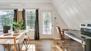 A dining area with a wooden table, white chairs, and a potted plant. - A-frame Home ~ 6 Mi to Tennessee River! (Florence)